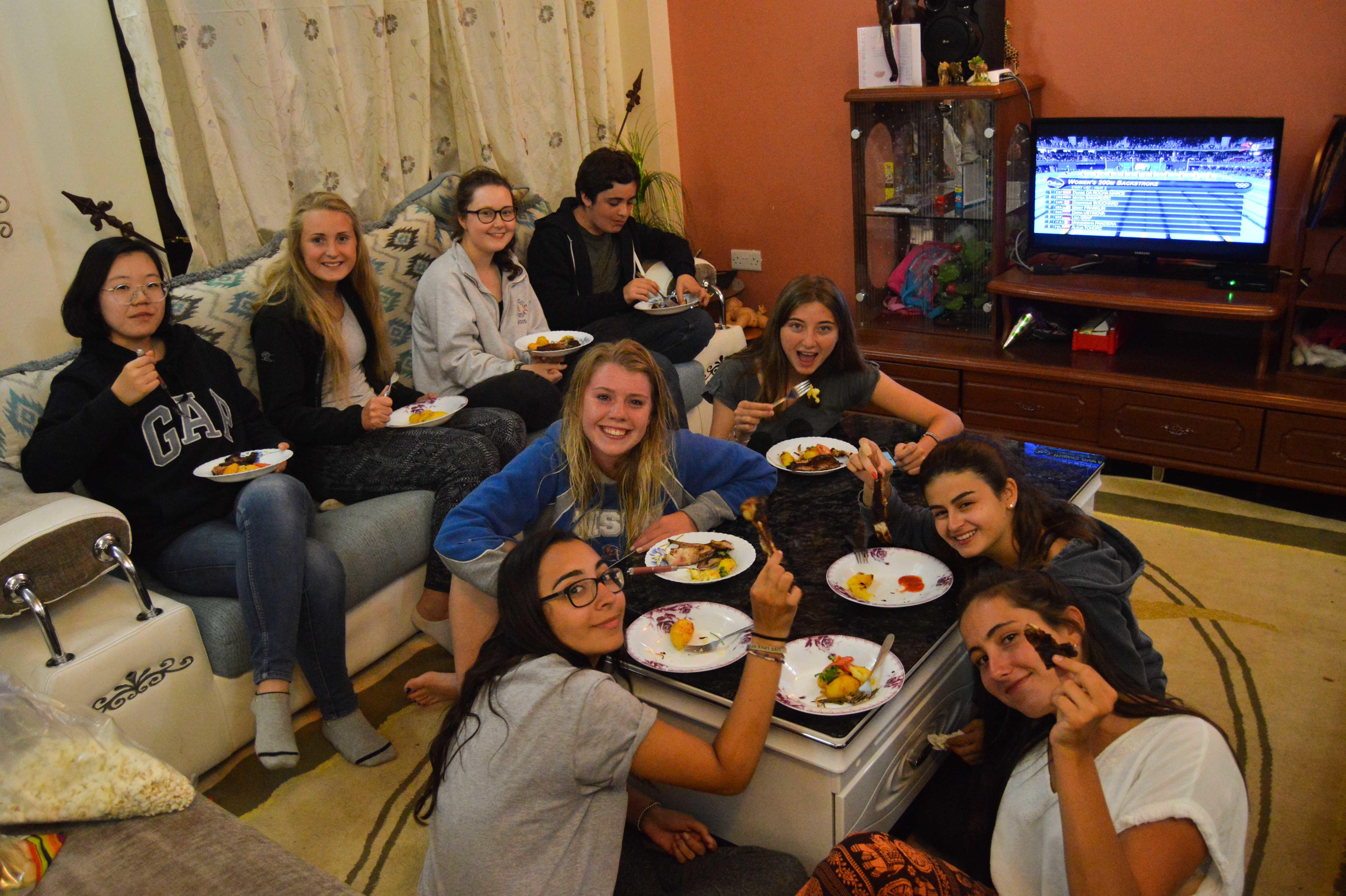 Volunteers enjoy their meal in their shared accomodation. Volunteers eat together in their shared accommodation after a day of hard work